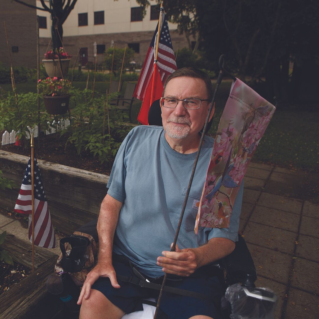 Resident posing for picture outside, in a wheelchair
